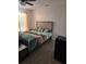 Bedroom features wood-look floors, a bed with an artistic duvet, and bright window with sheer curtains at 5391 Baldock Ave, Spring Hill, FL 34608