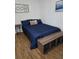 Comfortable bedroom featuring wood-look flooring, a ceiling fan, and a bed with stylish blue bedding at 5391 Baldock Ave, Spring Hill, FL 34608
