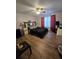 Bright bedroom with wood flooring, ceiling fan, and windows with red curtains at 5391 Baldock Ave, Spring Hill, FL 34608