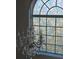 Crystal chandelier hanging below a round-top window with decorative stained glass at 5391 Baldock Ave, Spring Hill, FL 34608