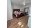 Spacious bedroom featuring wood-look flooring, a ceiling fan, and a large bed with stylish linens at 5391 Baldock Ave, Spring Hill, FL 34608