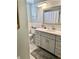 Bathroom with white vanity, a mirror, and white tiled walls and flooring at 5645 97Th N Way, St Petersburg, FL 33708