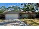 Charming brick home featuring a well-maintained front yard and an attached two-car garage at 5645 97Th N Way, St Petersburg, FL 33708