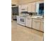 Well-lit kitchen with white cabinetry, modern appliances, and a tile backsplash at 5645 97Th N Way, St Petersburg, FL 33708