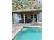Covered poolside patio with comfortable seating and ceiling fans for relaxing outdoor living at 5645 97Th N Way, St Petersburg, FL 33708