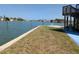 Beautiful waterfront backyard with lush green grass, private dock access, and staircase to elevated deck at 5930 Bahama N Way, St Pete Beach, FL 33706