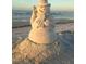 Unique sand snowman decoration on a sunny beach with ocean waves in the background at 5930 Bahama N Way, St Pete Beach, FL 33706