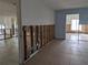 Open-concept living room showcasing stud framing, tile flooring, and easy access to adjacent rooms ready for upgrades at 5930 Bahama N Way, St Pete Beach, FL 33706