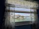 Stunning waterfront view through a butterfly-themed sheer curtain capturing boats and distant buildings from a cozy interior at 5930 Bahama N Way, St Pete Beach, FL 33706