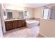 Bright bathroom with a large soaking tub, separate shower, and a dual sink vanity; modern design at 621 Washita Stone Dr, Ruskin, FL 33570