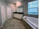 Bathroom featuring a large tub, granite countertop, and tile flooring at 6244 English Hollow Rd, Tampa, FL 33647