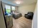 Cozy bedroom with an accent chair, blinds, and hard wood flooring at 6244 English Hollow Rd, Tampa, FL 33647