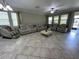 Expansive living room with tile flooring, large windows, comfortable leather seating, and massage chair at 6244 English Hollow Rd, Tampa, FL 33647