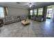 Bright living room with tile flooring, large windows, and comfortable leather seating at 6244 English Hollow Rd, Tampa, FL 33647