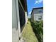View of the side yard, featuring a narrow green space and fence at 6244 English Hollow Rd, Tampa, FL 33647