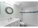 Bright bathroom features a vanity, toilet, and tiled tub with shower at 6307 S Cameron Ave, Tampa, FL 33616