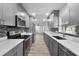 Galley kitchen featuring stainless appliances, gray cabinetry, and tile backsplash at 6307 S Cameron Ave, Tampa, FL 33616
