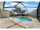 Screened in pool with brick-paved area, surrounded by lush greenery and serene privacy at 6307 S Cameron Ave, Tampa, FL 33616