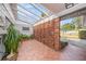 Inviting tiled entrance with a unique brick wall and a bright, open pergola at 6811 N Himes Ave, Tampa, FL 33614