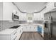 Modern kitchen featuring new white cabinets, subway tile backsplash, and stainless steel appliances at 6811 N Himes Ave, Tampa, FL 33614