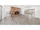 Open floor plan with fireplace, exposed brick wall, kitchen view, and screened patio access at 6811 N Himes Ave, Tampa, FL 33614