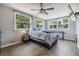 Bright bedroom with wood floors, ceiling fan, three windows with natural light, and a mounted television at 6816 13Th N St, St Petersburg, FL 33702