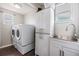 Well-lit laundry room with washer, dryer, storage cabinet and sink at 6816 13Th N St, St Petersburg, FL 33702