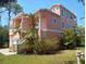 Beautiful peach house with white trim, a two-car garage, and a well-maintained lawn at 6926 Mccray Dr, Hudson, FL 34667