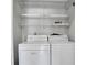 Laundry room complete with washer, dryer, and wire shelving at 7360 Ulmerton Rd # 17D, Largo, FL 33771