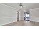 Spacious living room with wood-look floors, neutral walls, and a sliding glass door leading to the patio at 7360 Ulmerton Rd # 17D, Largo, FL 33771