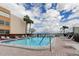 Community pool and sundeck offer a refreshing oasis with lounge chairs and palm trees under a bright sky at 7425 Bay Island S Dr # 203, South Pasadena, FL 33707