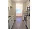 Galley kitchen with white cabinets, stainless steel appliances, and wood-look flooring at 7526 Needle Leaf Pl # 29, Tampa, FL 33617