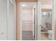 Hallway view of walk-in closet, bathroom, and utility closet with bi-fold doors at 8309 Pebble St, Spring Hill, FL 34608