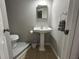 This bathroom features a pedestal sink and mosaic tile flooring surrounding the toilet at 943 7Th N St, St Petersburg, FL 33701