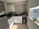 Bright kitchenette featuring white cabinets and stainless steel refrigerator at 943 7Th N St, St Petersburg, FL 33701