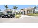 View of clubhouse entrance with golf carts parked nearby, with tropical landscaping at 10418 Spring Tide Way, Parrish, FL 34219