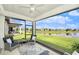 Relaxing screened lanai with comfortable seating and a tranquil view of the water and lush landscaping at 10418 Spring Tide Way, Parrish, FL 34219