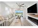 Bright living room with an electric fireplace, coastal decor, and sliding glass doors to outdoor area at 10418 Spring Tide Way, Parrish, FL 34219