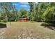 Aerial view of outbuilding and lawn, surrounded by mature trees in a serene setting at 11120 Lu Wista Ln, Brooksville, FL 34601