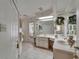 Bright bathroom featuring dual sinks, decorative wallpaper, vanity with a large mirror and great natural light at 11120 Lu Wista Ln, Brooksville, FL 34601