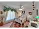 Bright bedroom with a vintage bedframe, rug, ceiling fan and a large window bringing in lots of light at 11120 Lu Wista Ln, Brooksville, FL 34601