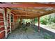 Attached carport to outbuilding providing covered parking or storage space, surrounded by lush greenery at 11120 Lu Wista Ln, Brooksville, FL 34601