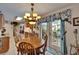 The dining room has decorative curtains and decor, a wood table and a view into the kitchen at 11120 Lu Wista Ln, Brooksville, FL 34601