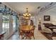 Dining area features French doors, chandelier, decor plate shelving, and wood table at 11120 Lu Wista Ln, Brooksville, FL 34601