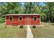 Charming red outbuilding featuring white trim, a gable roof, and a small front bench at 11120 Lu Wista Ln, Brooksville, FL 34601