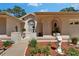 Inviting front entrance with lush landscaping, a decorative window, and a charming walkway at 11120 Lu Wista Ln, Brooksville, FL 34601