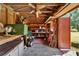 Outbuilding interior featuring shelves, storage containers and exposed wooden beams at 11120 Lu Wista Ln, Brooksville, FL 34601