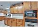 Kitchen showcases wood cabinets, stainless steel microwave and oven, and granite countertops at 11120 Lu Wista Ln, Brooksville, FL 34601