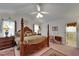 Spacious main bedroom with a four poster bed, ceiling fan and an attached bathroom for ultimate comfort at 11120 Lu Wista Ln, Brooksville, FL 34601