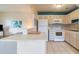 Kitchen with white appliances, a breakfast bar, and tile flooring at 11723 Boynton Ln # 1, New Port Richey, FL 34654